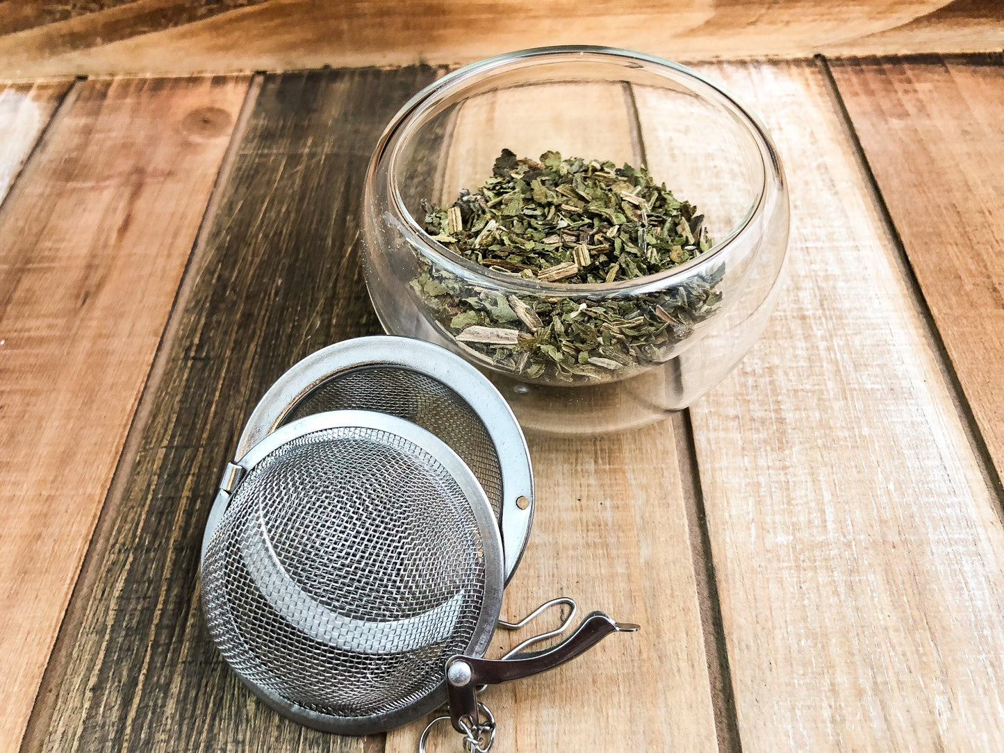 Dried comfrey herb from HerbalRoseApothecary, showing green leaves and stems in a natural, rustic setting.