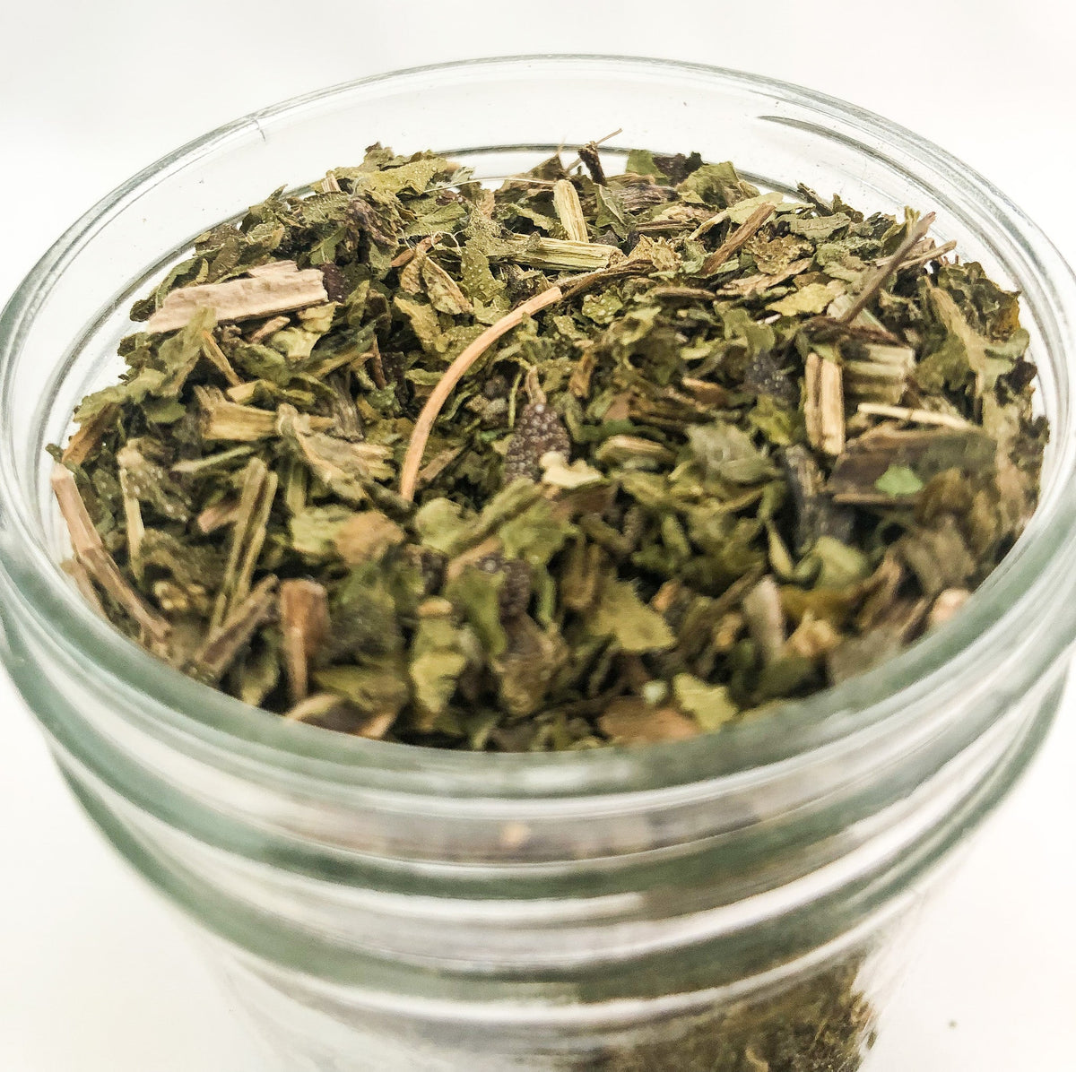 Small jar of dried comfrey herbs in herbalroseapothecary herb jar with white label, perfect for herbal remedies and natural healing.
