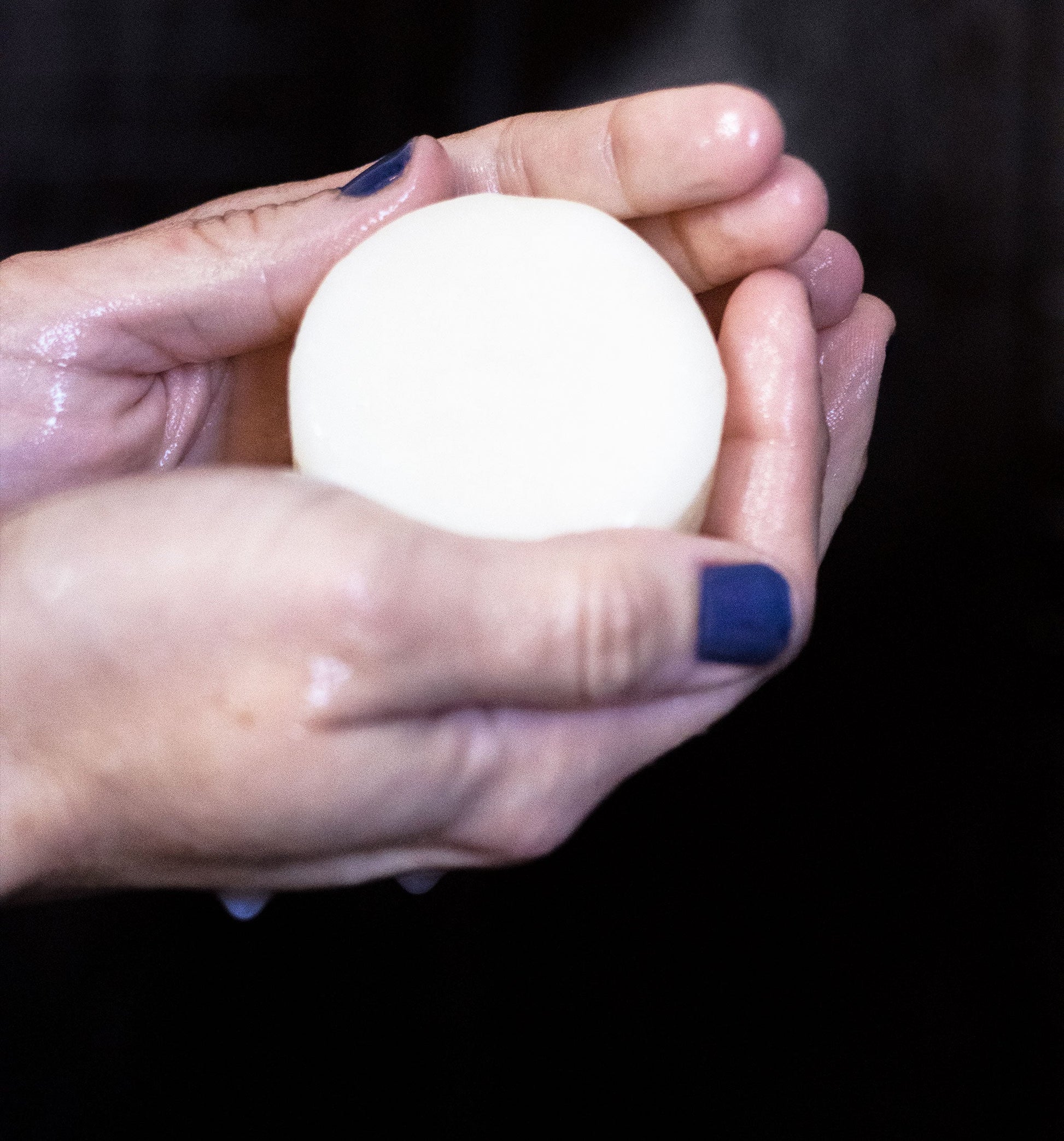 Hand holding Rock Creek Soaps Wild Nectar Conditioner Bar with argan oil, showcasing its natural, solid conditioner form.