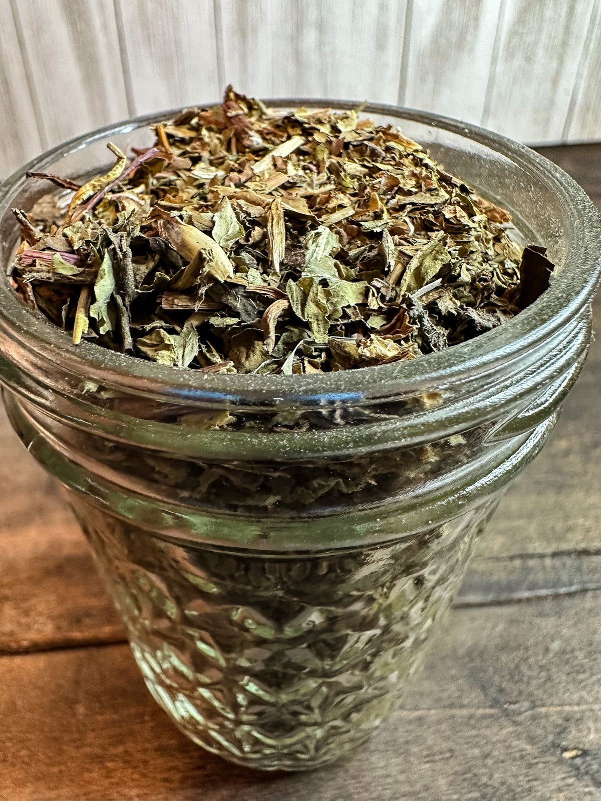 Small jar of dried dandelion herbs in a herbalroseapothecary herb jar for herbal remedies and teas.