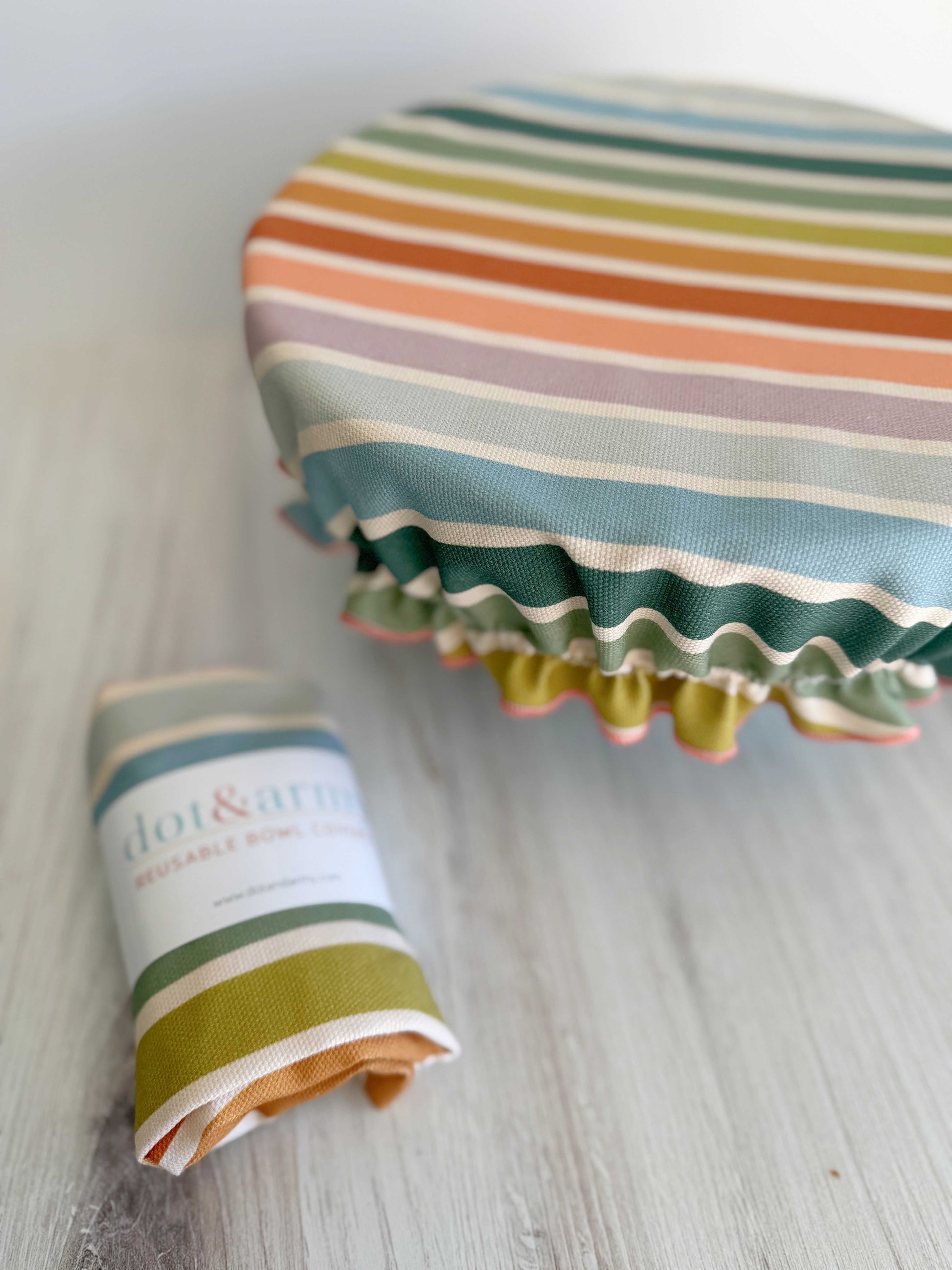 Reusable bowl cover with beach chair stripes by Dot and Army, designed for food containers, featuring a colorful striped pattern.
