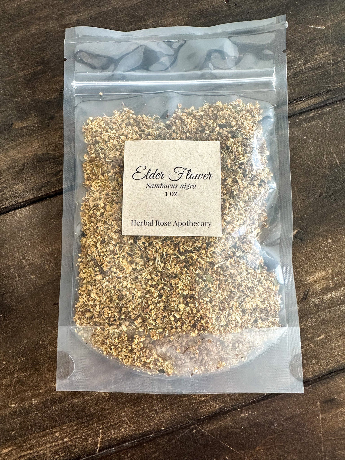 Dried elderflowers from HerbalRoseApothecary in 1oz package, showcasing small white and yellow dried herb blossoms.