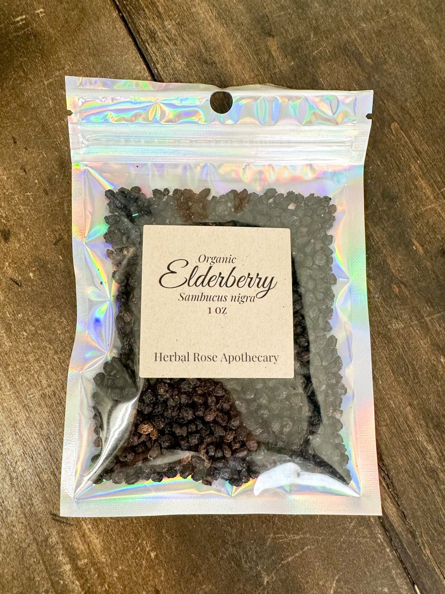 Dried organic elderberries in a 1oz herbalroseapothecary package, showcasing small dark purple berries for herbal remedy use.