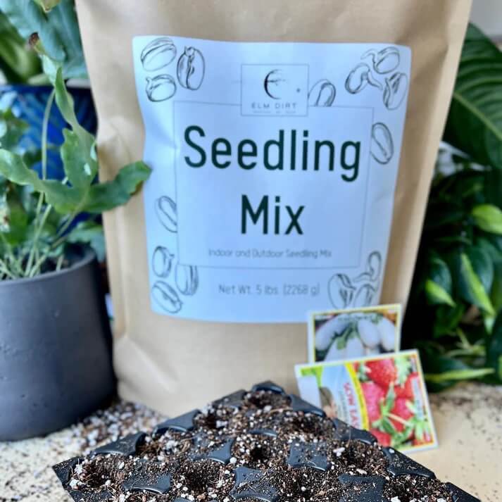 Elm Dirt Seedling Mix bag with rich soil and organic matter for healthy plant seedlings, shown in a natural outdoor setting.