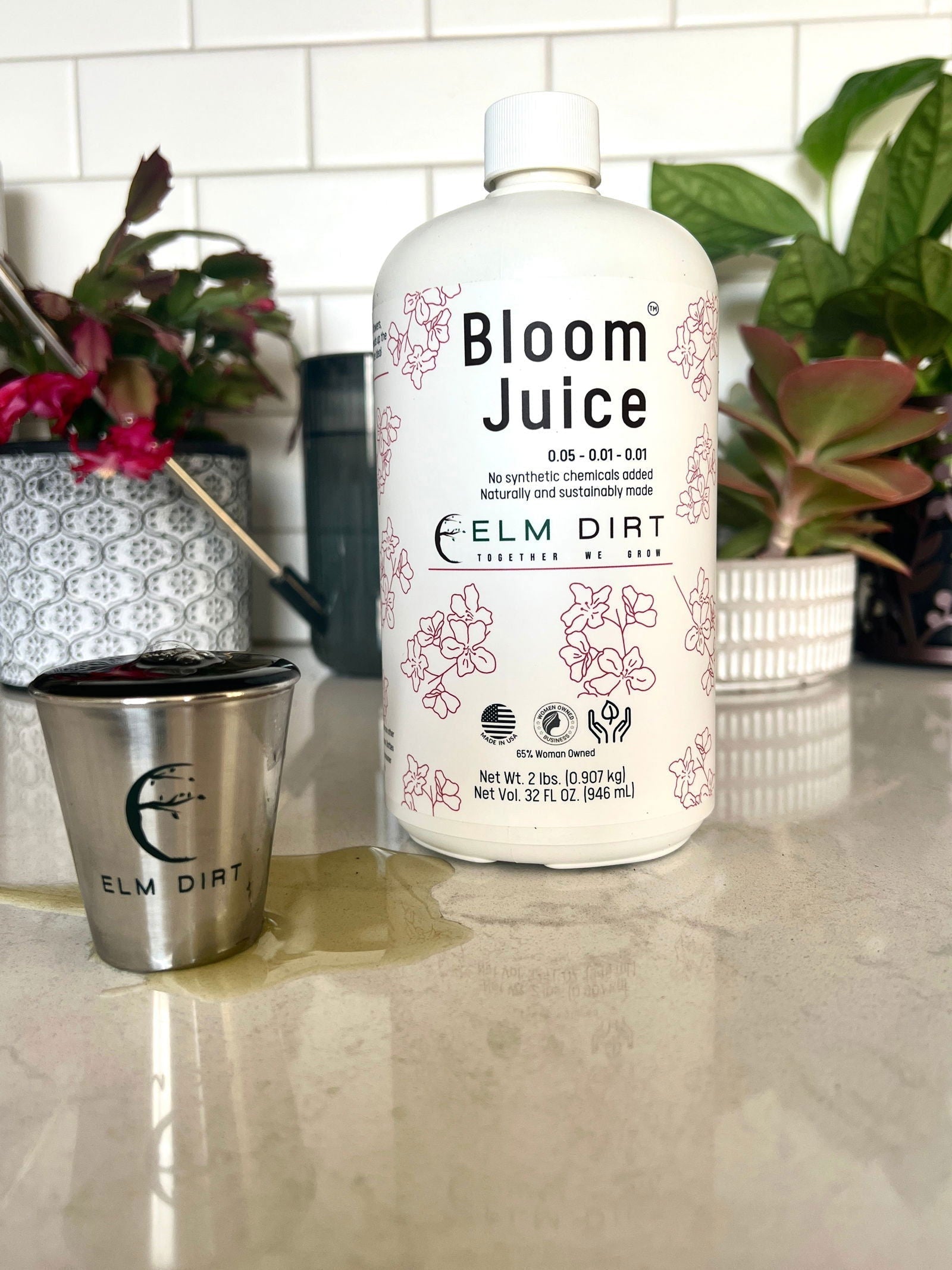 Elm Dirt Bloom Juice fertilizer bottles, 32 oz each, showing the vibrant packaging and product label for plant growth nourishment.