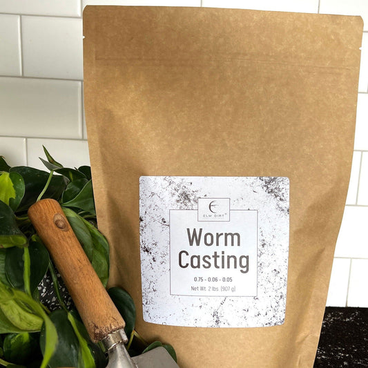 Two pounds of Elm Dirt worm castings, organic fertilizer rich in nutrients, shown in a clear container with soil and worms.