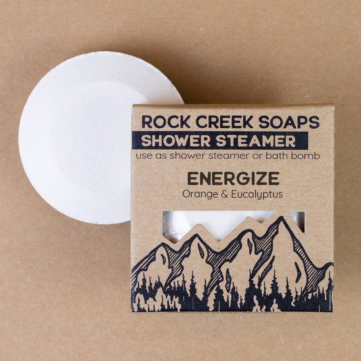 Rock Creek Soaps Energize shower steamer for shower and bath, with vibrant citrus and mint scent, in a clear container.
