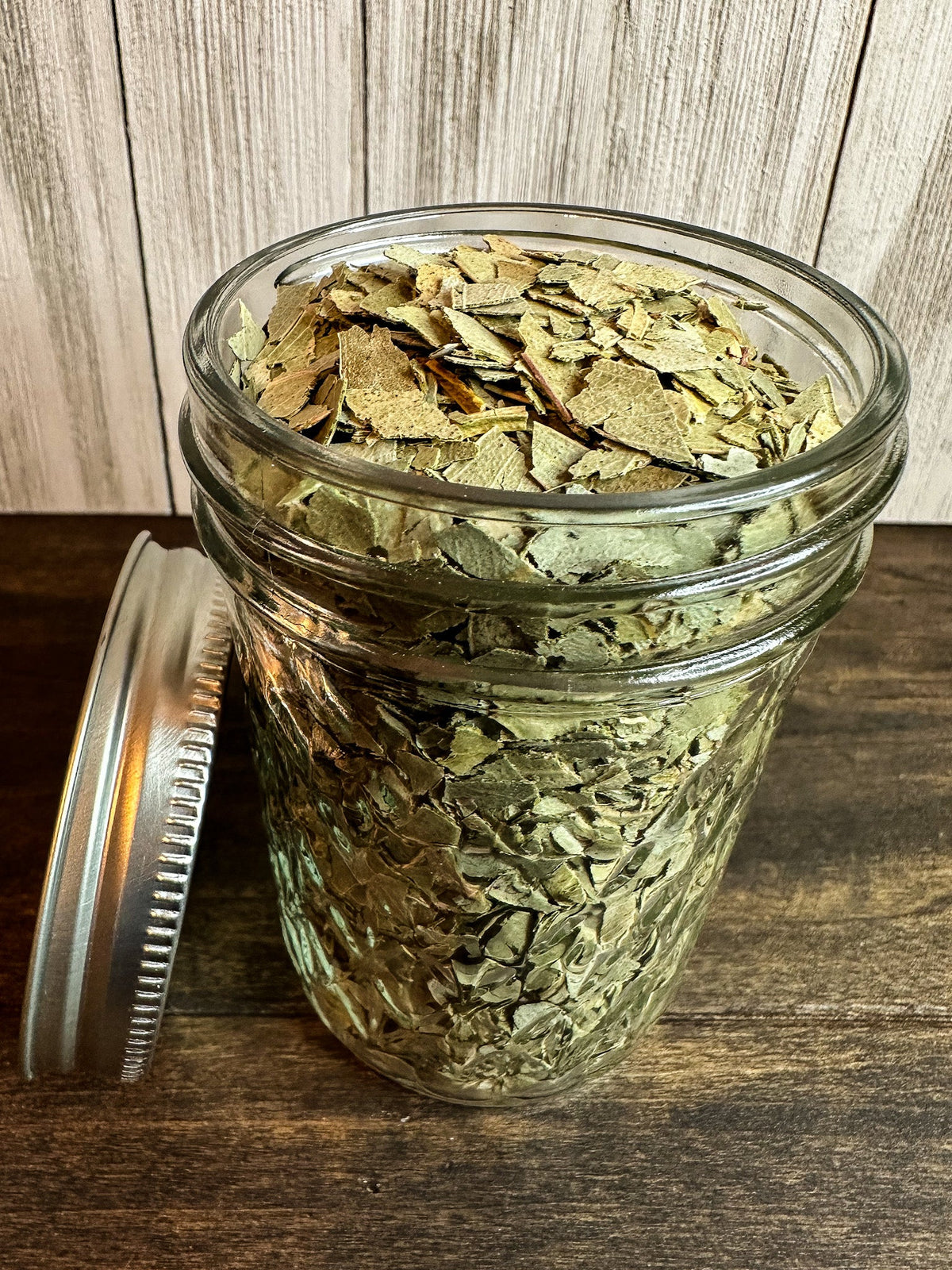 Small herbal jars from HerbalRoseApothecary containing dried eucalyptus herbs, displayed on a neutral background.