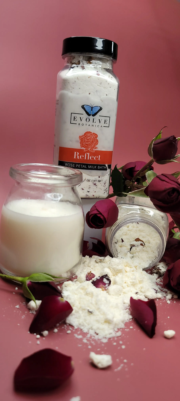 Evolve Botanica Reflect Rose Milk Bath with soft pink powder and floral ingredients, displayed in a clear jar.