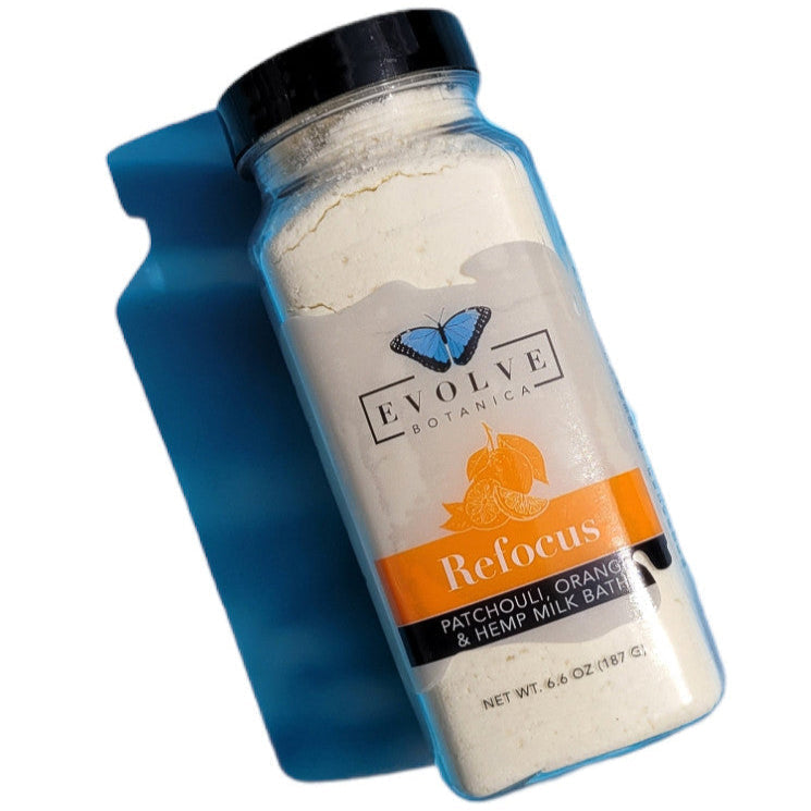 Evolve Botanica Milk Bath Refocus with patchouli, orange, and hempseed oil in a relaxing bath setting.