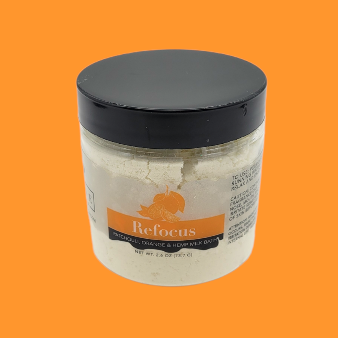 Mini Milk Bath by Evolve Botanica with patchouli, orange, and hempseed oil, showcasing the soothing bath powder in a natural setting.
