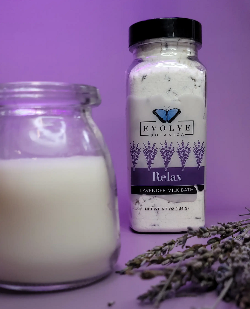 Evolve Botanica Relax Lavender Milk Bath with calming lavender flowers and creamy milk in a clear glass jar.