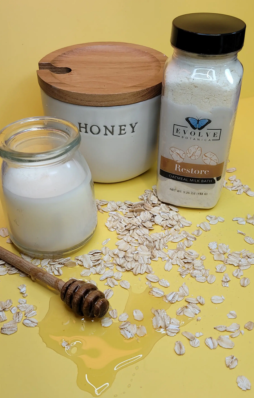 Evolve Botanica Milk Bath Restore with Oatmeal in a white tub, creamy milk bath powder for soothing skincare.