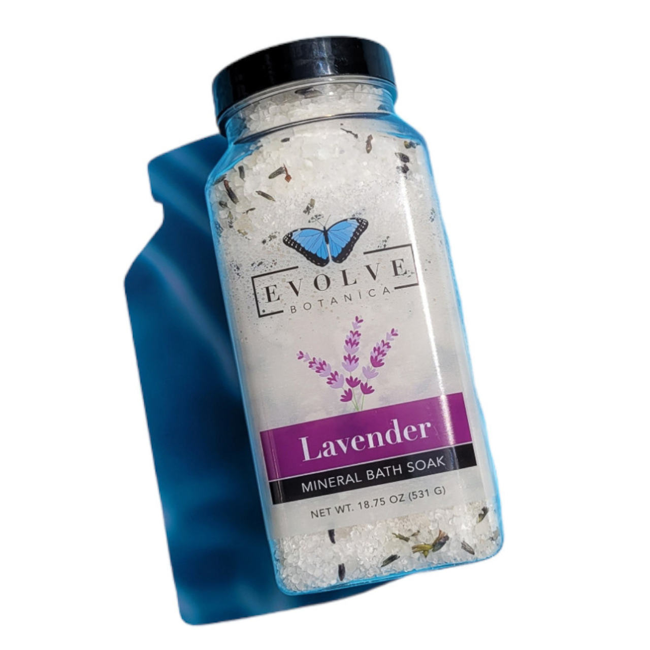 Evolve Botanica Mineral Soak Lavender Spa bath salt in a jar with lavender flowers and a wooden scoop, ready for a relaxing bath.