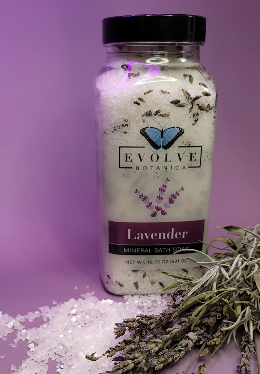 Evolve Botanica Mineral Soak Lavender Spa bath salt in a clear jar with lavender flowers and salt crystals for relaxing bath time.
