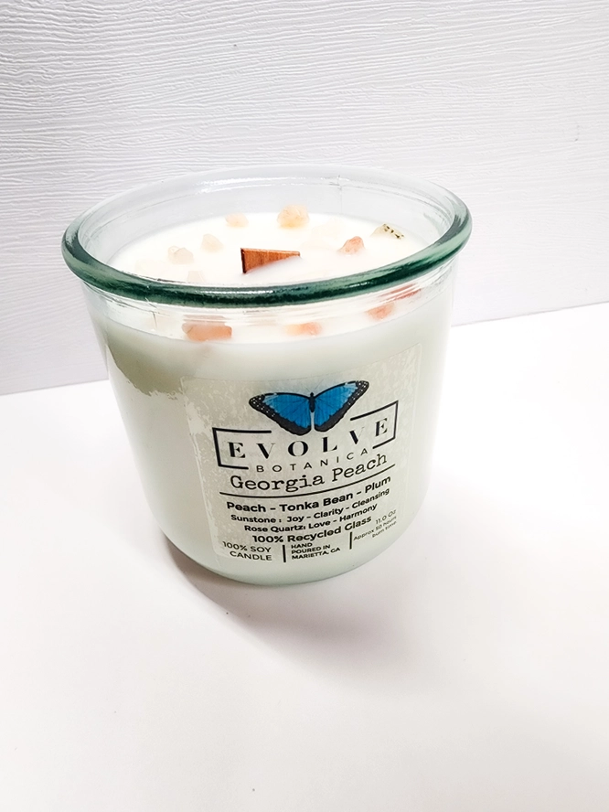 Georgia Peach soy candle by Evolve Botanica with gemstone accents and wood wick, offering a warm, fruity aroma.