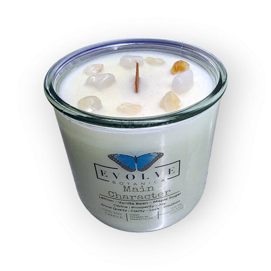 Evolve Botanica Rocks Candle Main Character with wood wick, Citrine and Snow Quartz gemstones, soy wax, and decorative stones.