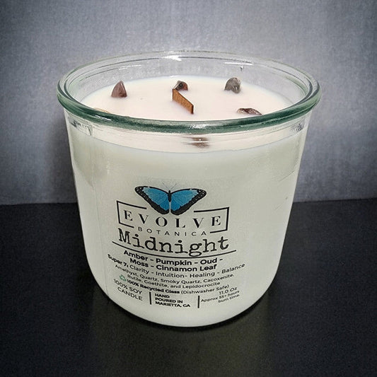 Evolve Botanica Midnight Rocks Candle with wood wick and Super Seven gemstone soy wax, featuring layered candles and gemstone accents.