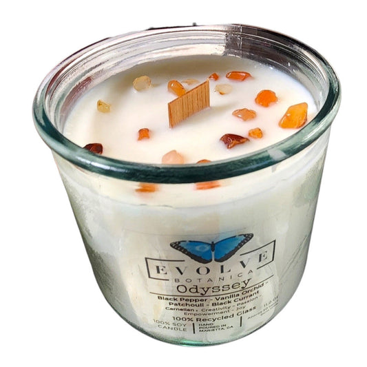 Evolve Botanica Rocks Candle Odyssey with wood wick, Carnelian gemstone, and soy wax in a decorative jar.