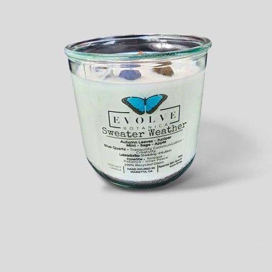 Evolve Botanica Rocks Candle Sweater Weather with wood wick, Howlite, Labradorite, Sodalite, and soy wax in a cozy setting.