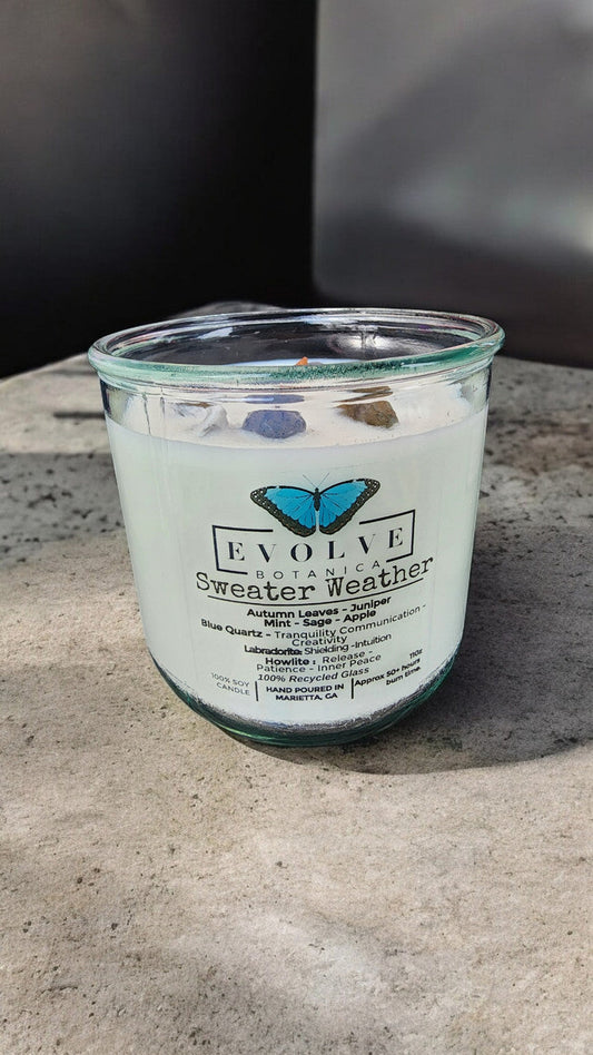 Evolve Botanica Rocks Candle Sweater Weather with wood wick, howlite, labradorite, and sodalite, soy wax for a calming ambiance.