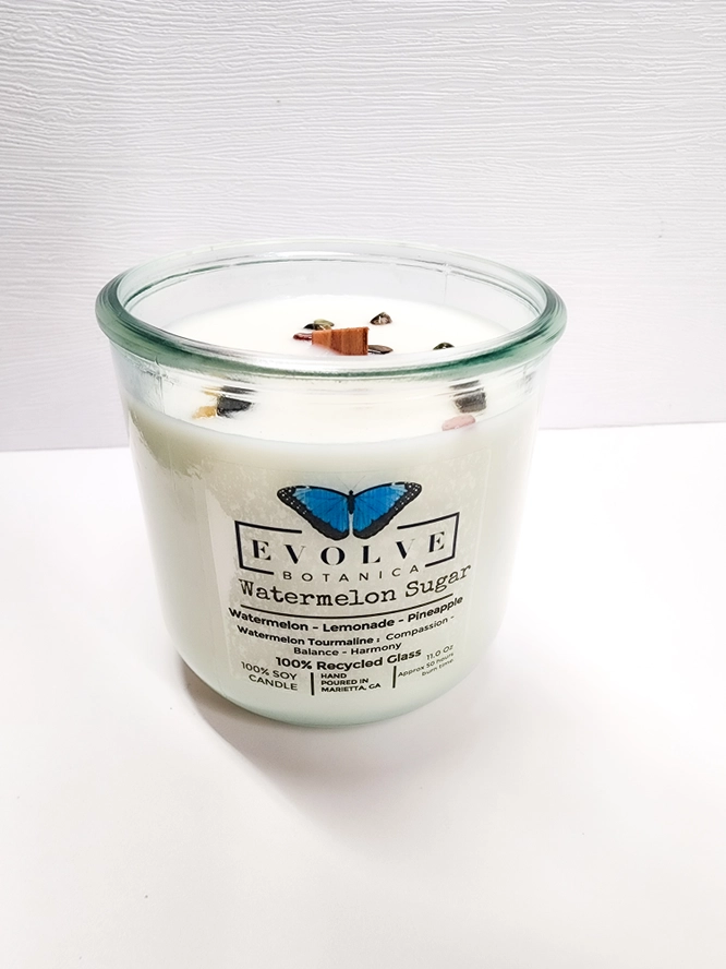 Evolve Botanica Watermelon Sugar Rocks Candle with wood wick and gemstone, soy wax in a decorative container.