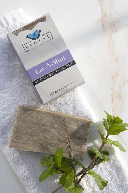 Evolve Botanica Lav-A-Mint Dead Sea Mud facial soap in a clear glassine bag, showcasing the natural soap bar with mint and mud ingredients.
