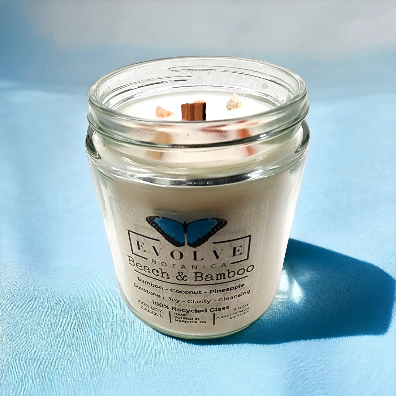 Evolve Botanica Classic 9oz Jam Jar Crystal Soy Candle with beach and bamboo scent, natural wood wick, Sunstone color.