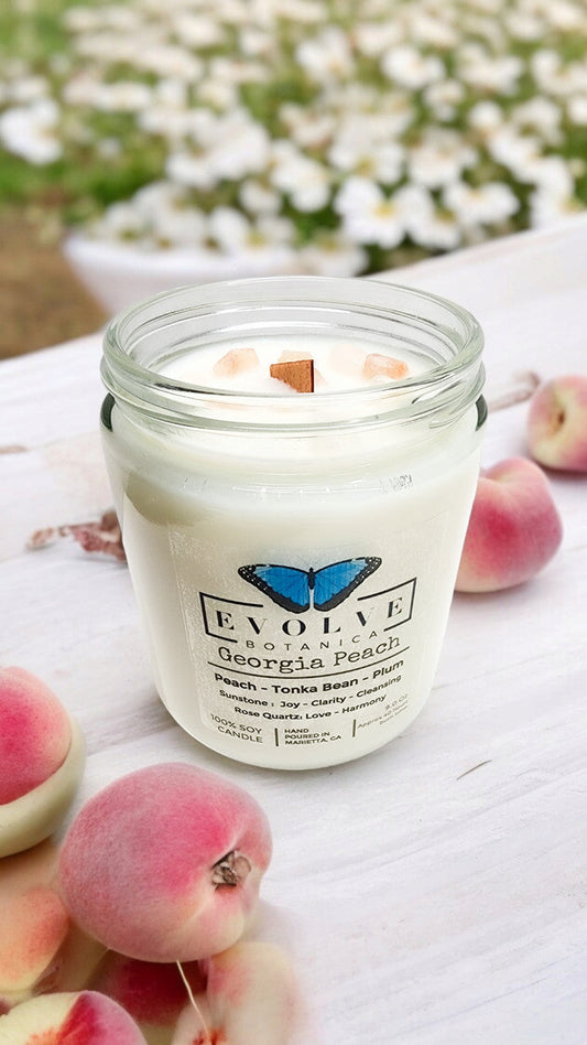 Evolve Botanica 9oz jam jar soy candle with Georgia Peach scent, featuring Sunstone and Rose Quartz crystals, natural wood wick.
