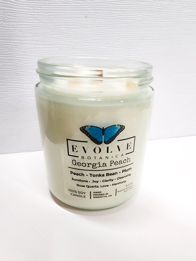 Evolve Botanica 9oz jam jar soy candle with Georgia Peach scent, featuring sunstone and rose quartz crystals, natural wood wick