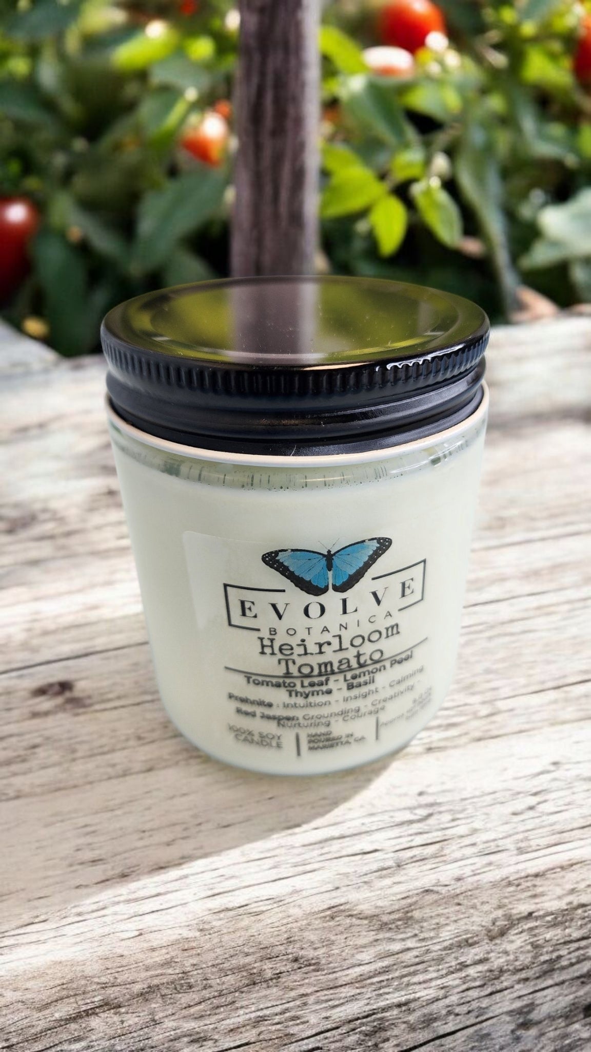 Evolve Botanica 9oz jam jar soy candle with heirloom tomato scent, featuring prehnite and red jasper crystals and a natural wood wick.