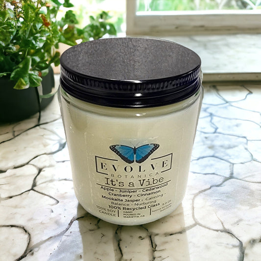 Evolve Botanica 9oz jam jar soy candle with natural wood wick, featuring Mookite Jasper crystal for ambiance and relaxation.