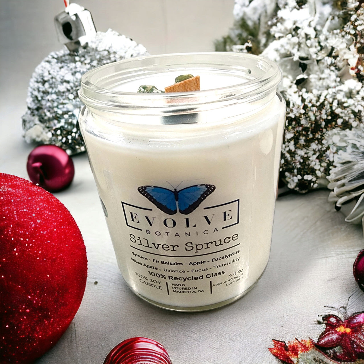 Evolve Botanica 9oz Jam Jar soy candle with Silver Spruce scent, crystal moss agate, natural wood wick, and elegant design.