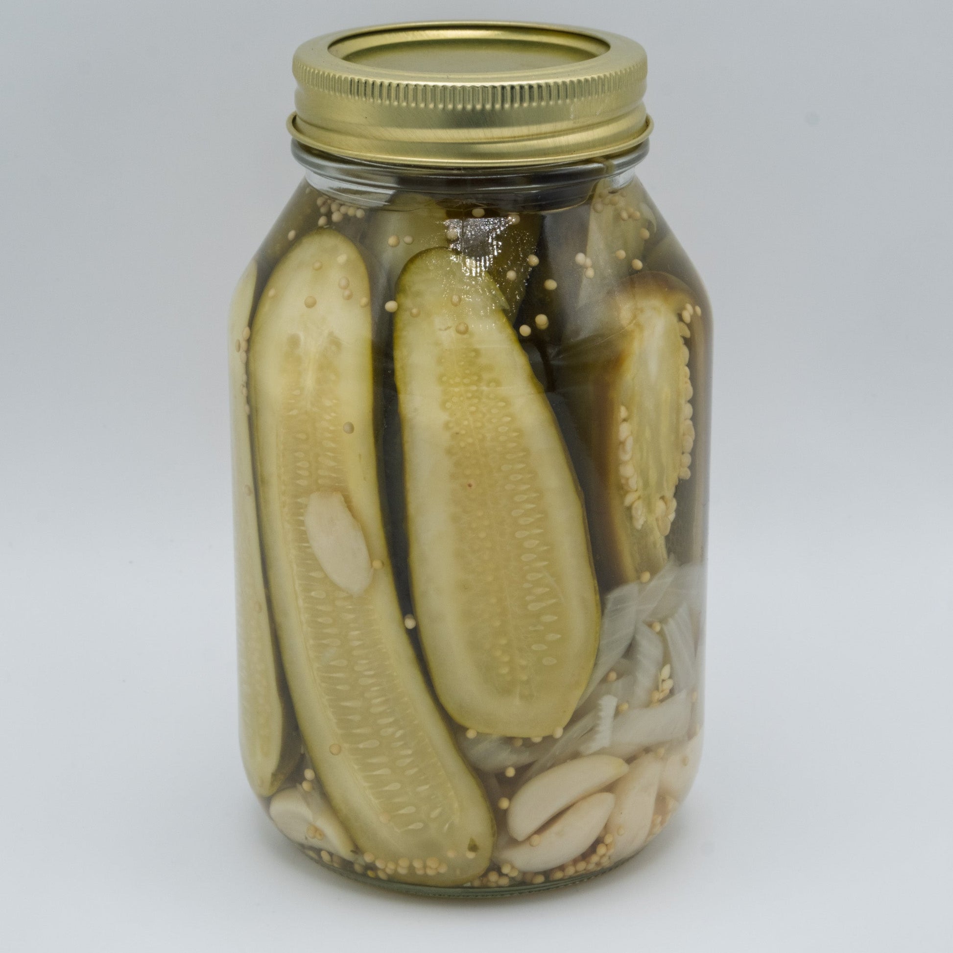 Canned farmhouse pickles jar from Amish Country Store with green and yellow label, showcasing fresh pickles inside.