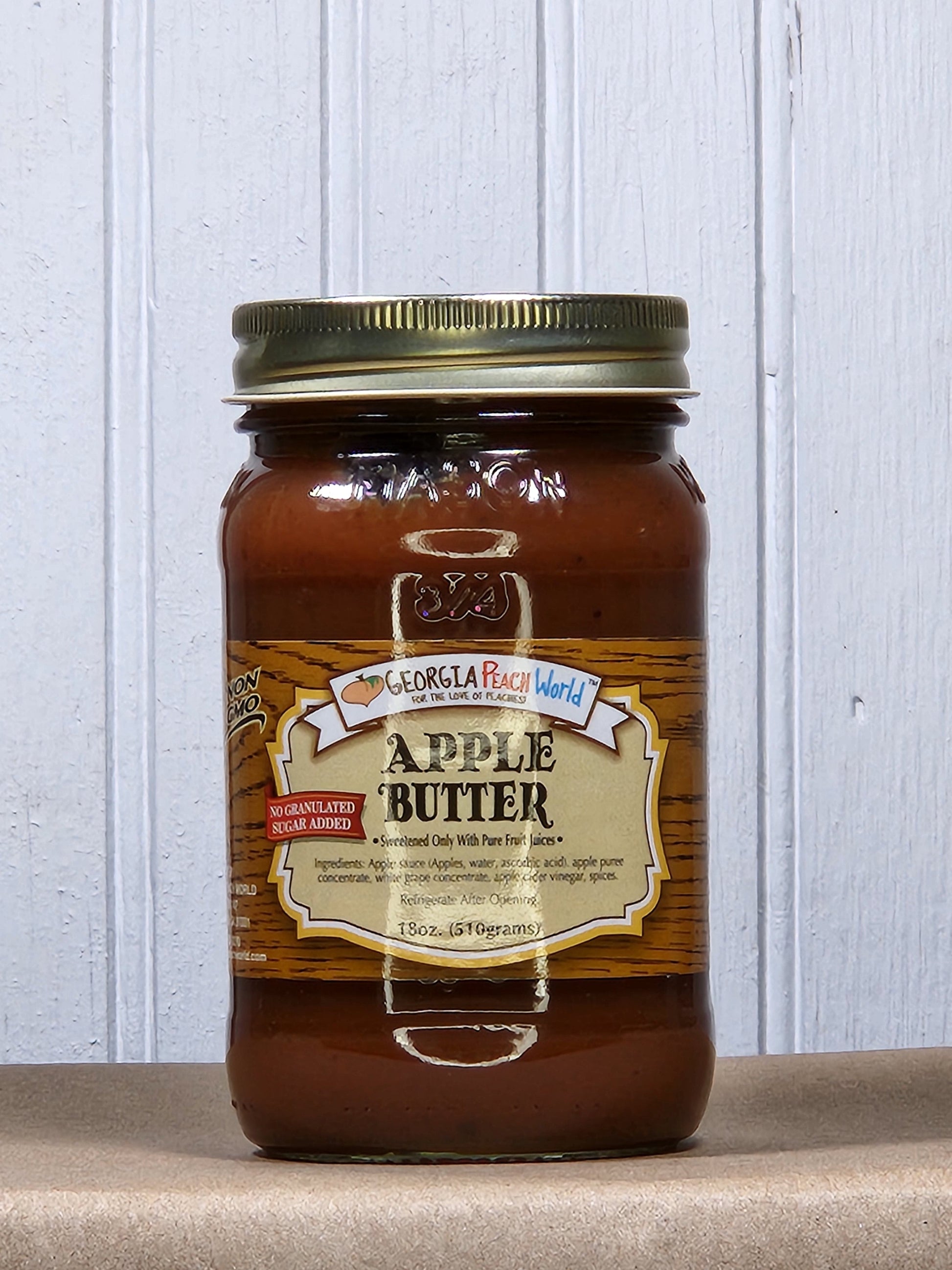 Creamy apple butter from Georgia Peach World, no sugar added, spread in a jar, showcasing a smooth, golden-brown texture.