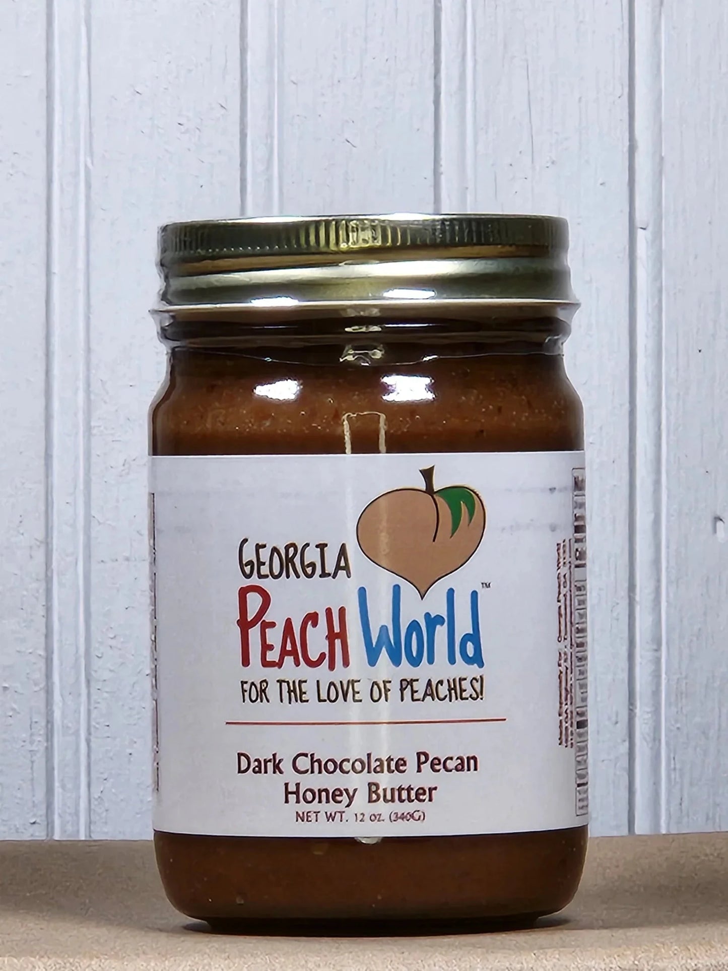 Assorted flavors of Georgia Peach World Pecan Honey Butter spread in glass jars, showcasing rich textures and colorful labels.