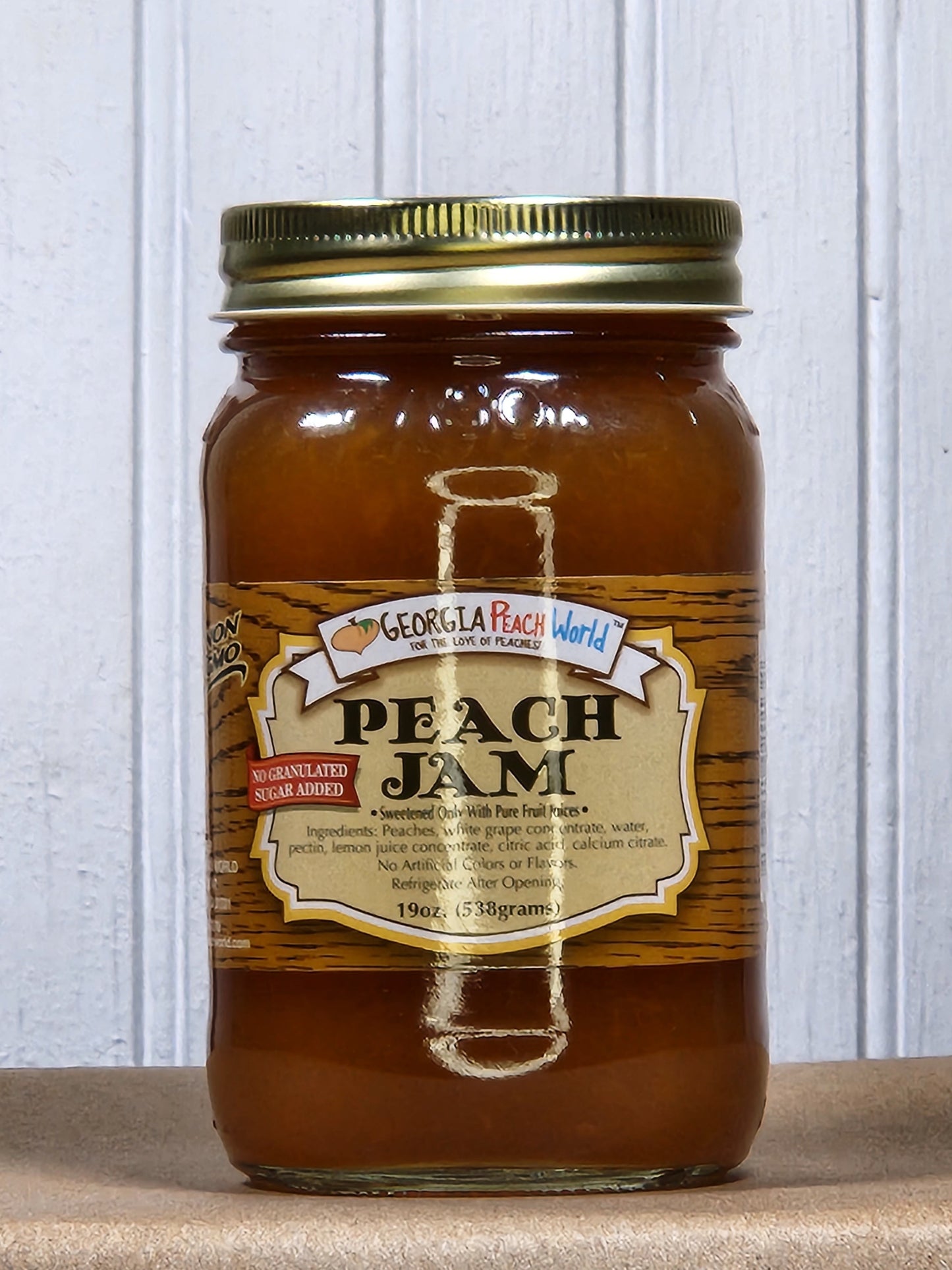Jar of Georgia Peach World no sugar added peach jam with fresh peach chunks inside, showcasing natural fruit and smooth texture.