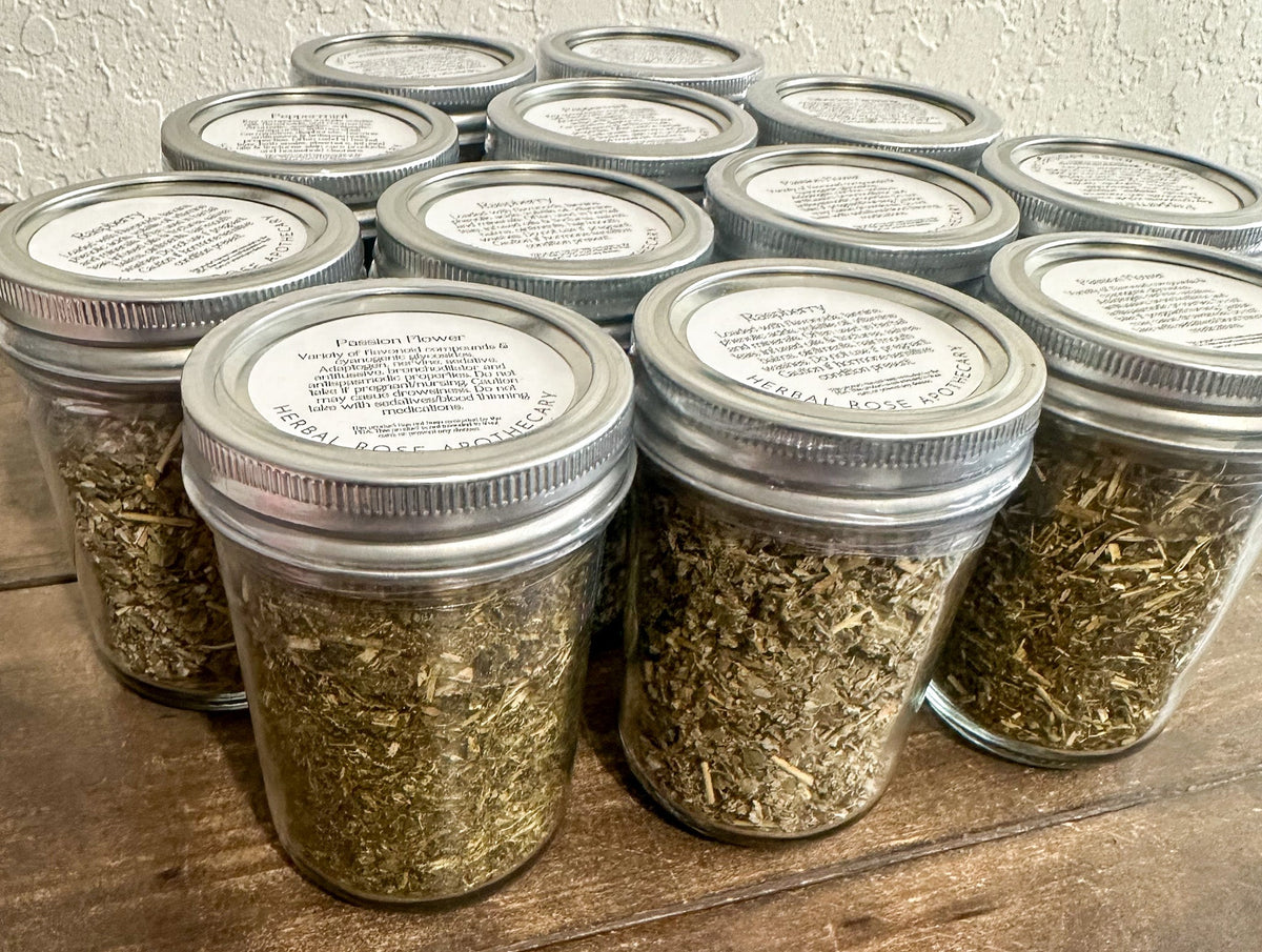 Small glass jars filled with dried herbs from Herbal Rose Apothecary, showcasing herb jars with colorful dried plant contents.
