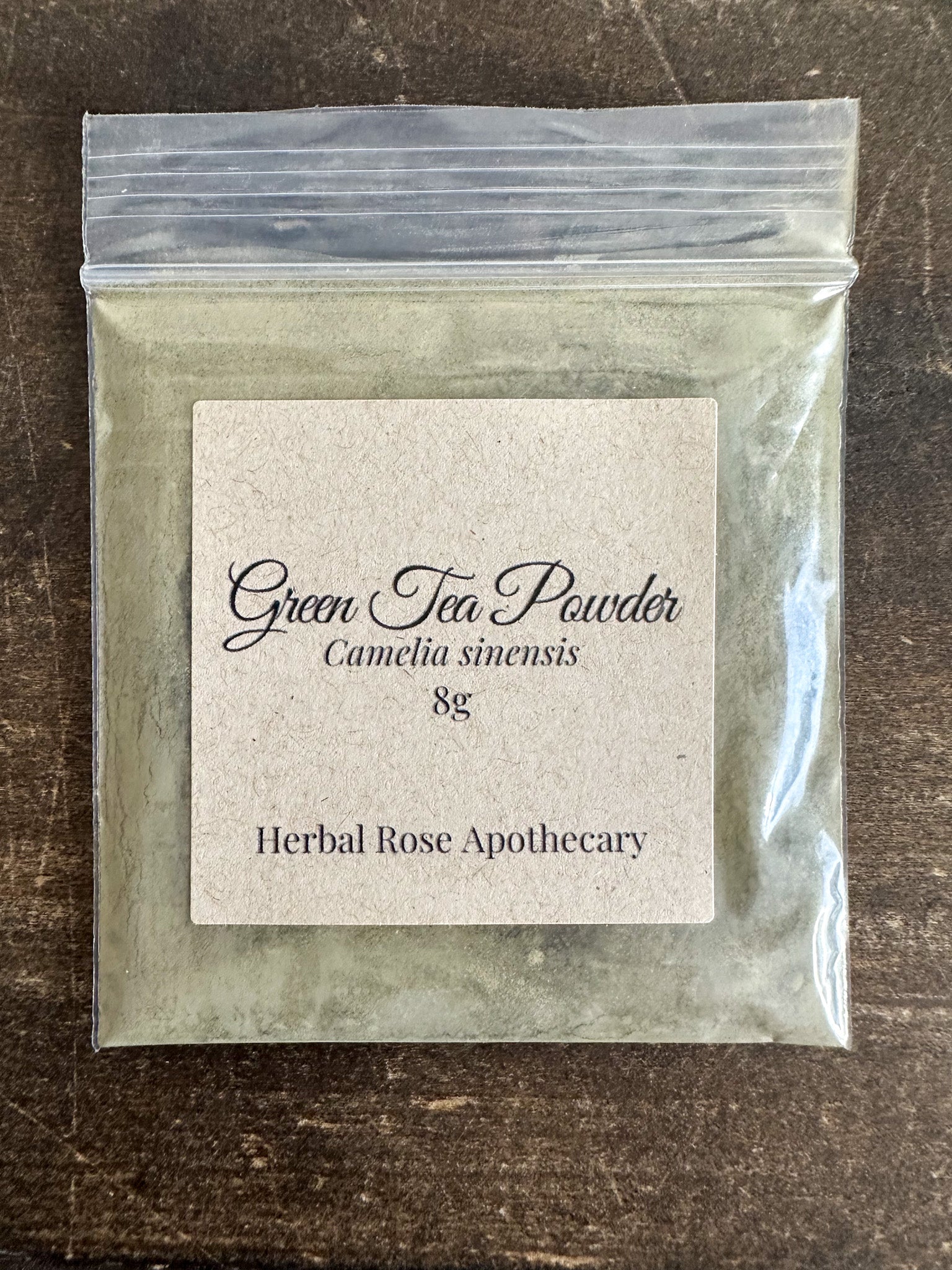 Dried green tea powder in an 8g package by HerbalRoseApothecary, showing vibrant green powdered herbal tea.