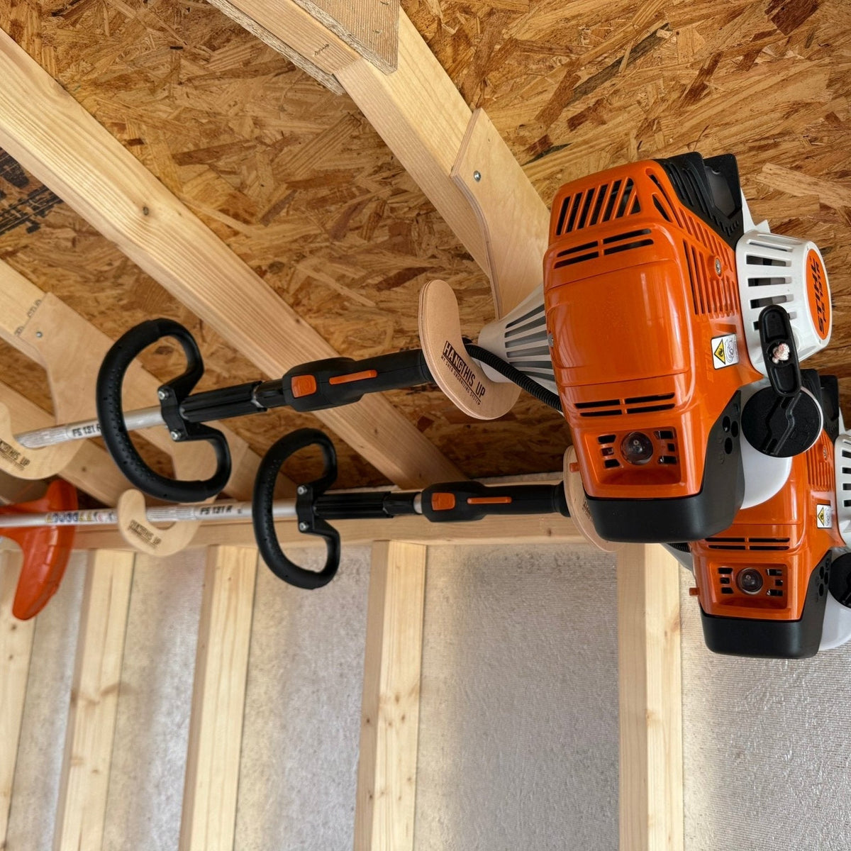 Overhead weed wacker rack by HangThis Up, ceiling mount outdoor shed organizer for garden tools and equipment storage.