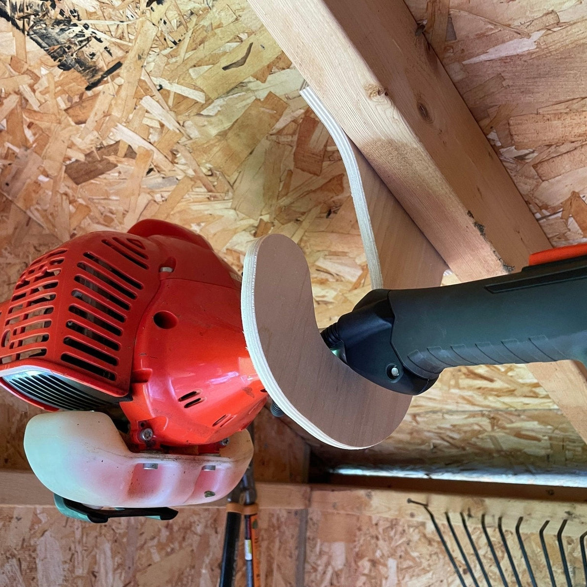 Overhead Weed Wacker Rack by HangThis Up mounted on shed ceiling for outdoor storage organization.