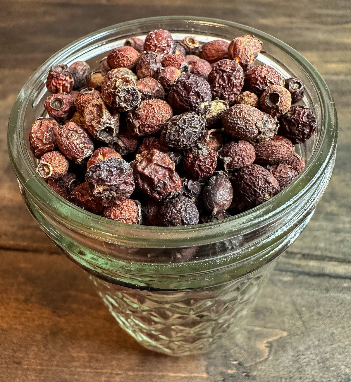 Small jar of dried hawthorn berries from HerbalRoseApothecary herb jars collection, showcasing vibrant red berries inside a glass jar.
