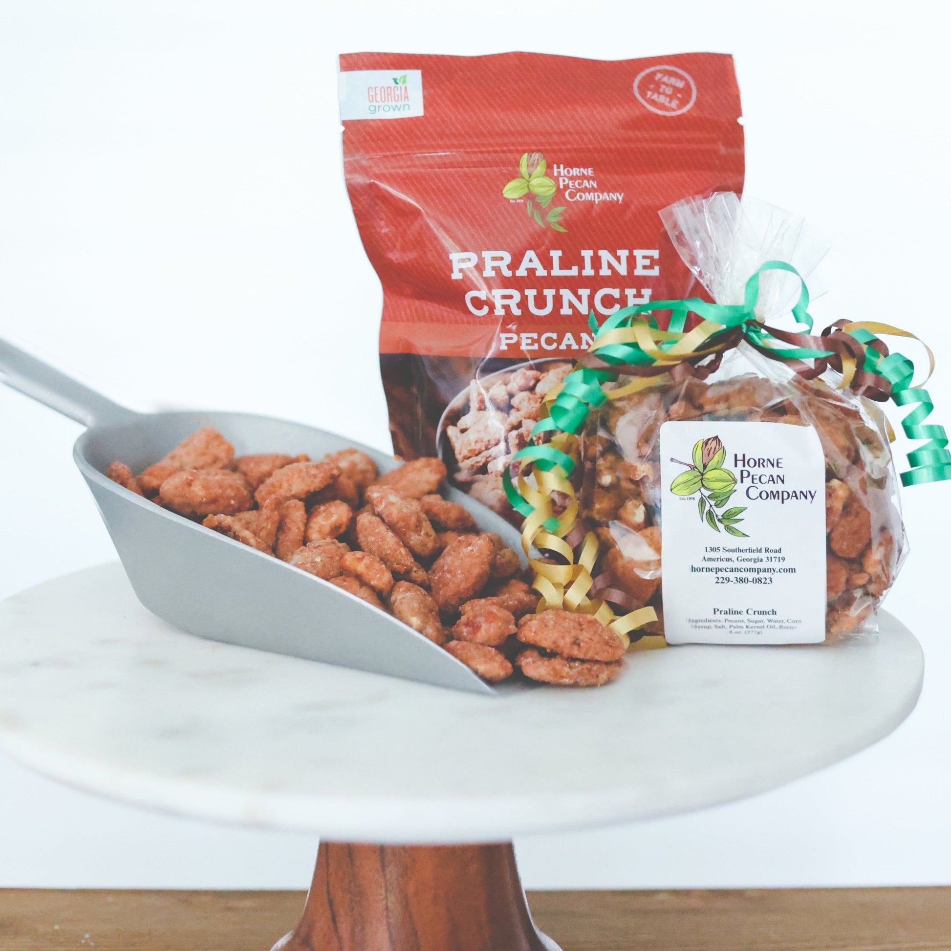 Praline-coated pecans from Horne Pecan Company in a 2 oz candy bag, showcasing glossy, crunchy pecans covered in sweet praline coating.