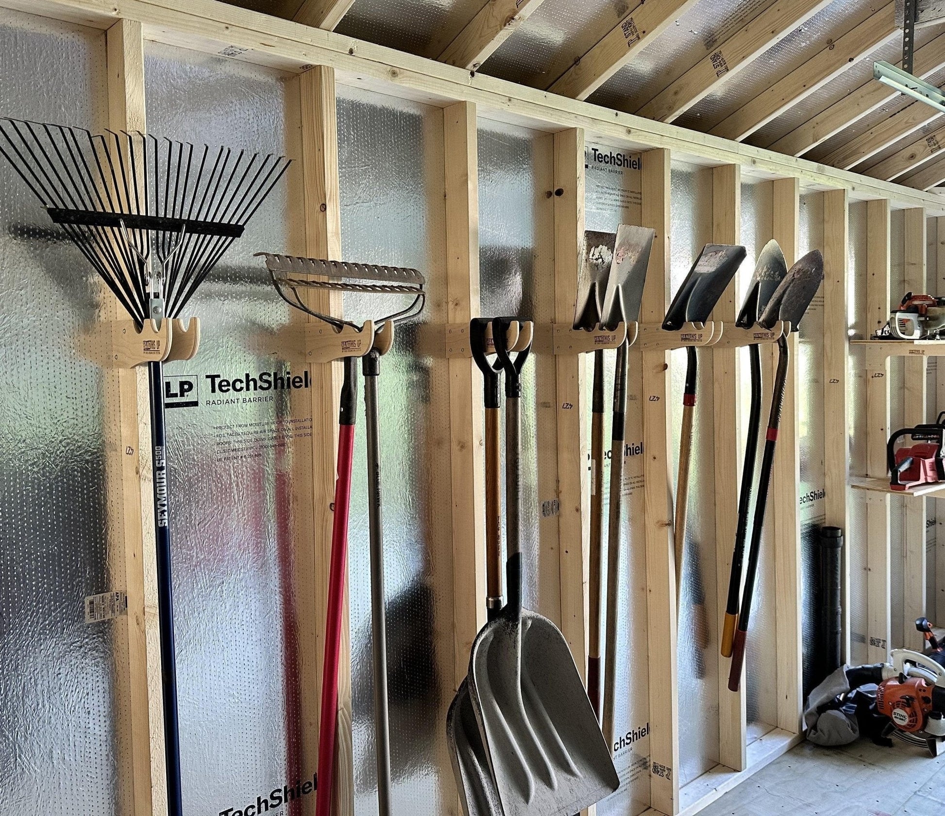 HangThis Up garden tool organizer in a shed, outdoor storage rack for yard tools and garden accessories.