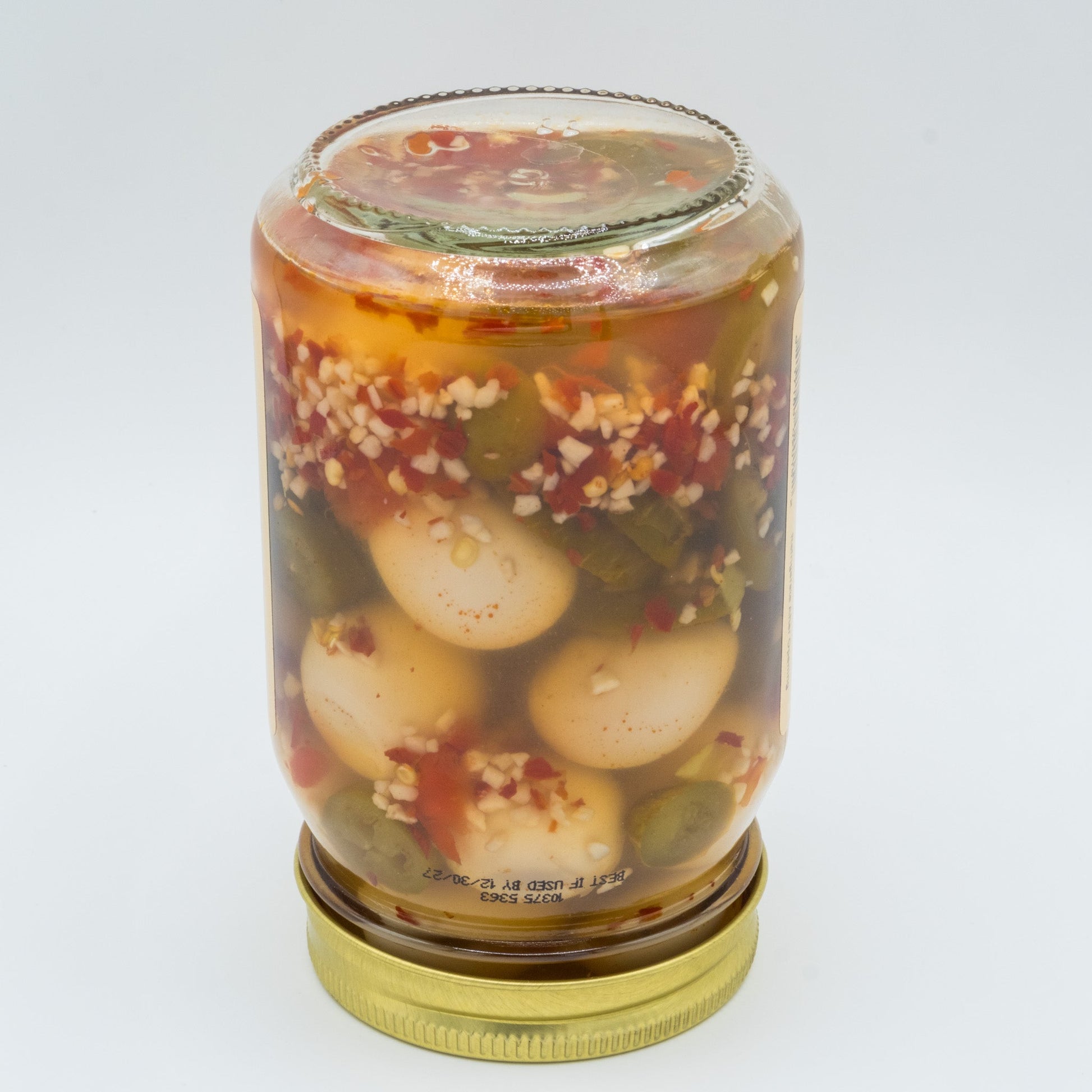 Canned Amish Country Store pickled jalapeño quail eggs in a jar with visible jalapeño slices and quail eggs inside.