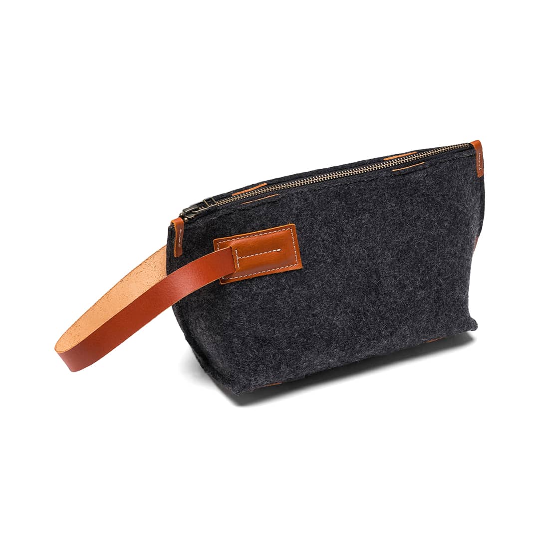Gray felt and leather wallet from Kyrgies, compact travel kit with multiple compartments and a sleek design.