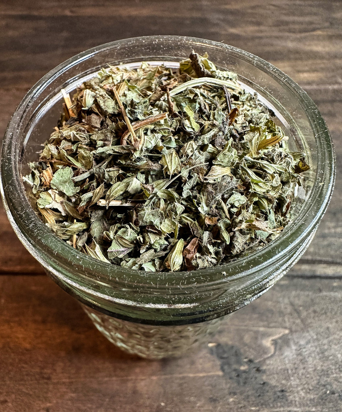 Small jar of dried lemon balm herbs in a herbalroseapothecary herb jar, showcasing fresh, dried lemon balm leaves.