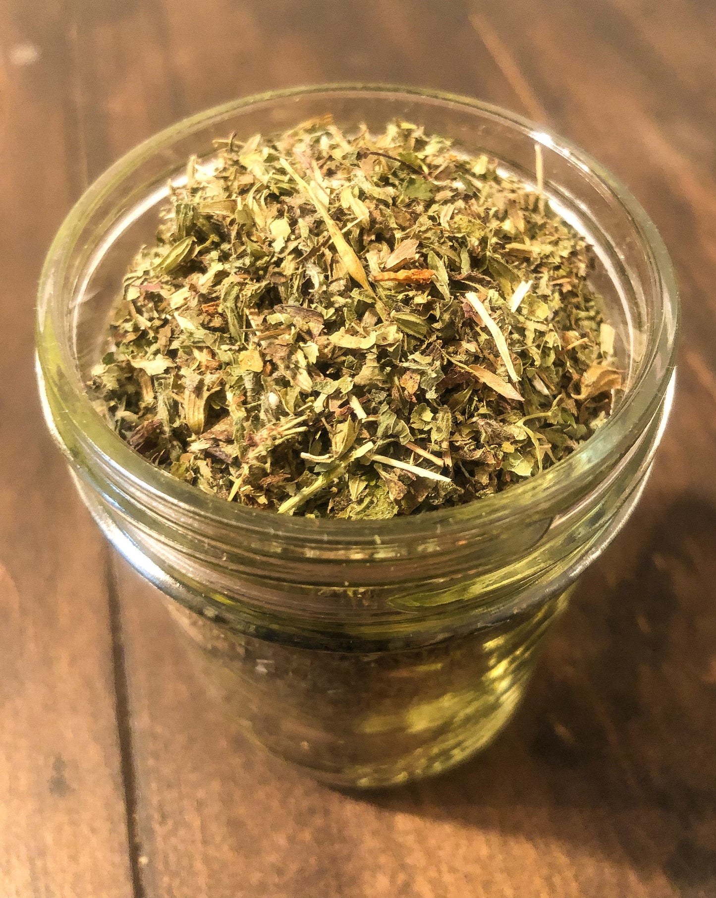 Small jar of dried lemon balm herbs in herbalroseapothecary herb jar, showcasing fresh dried lemon balm leaves.