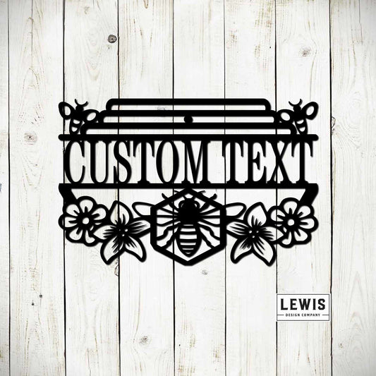 Personalized honey bee garden sign hanging outdoors, featuring custom black garden art from Lewis Design Company for patio decor.