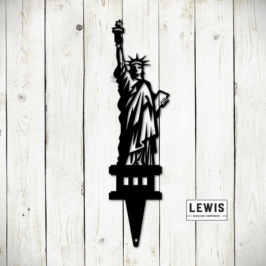 Black metal Statue of Liberty garden stake and yard art sign for outdoor patriotic decoration and 4th of July celebrations.